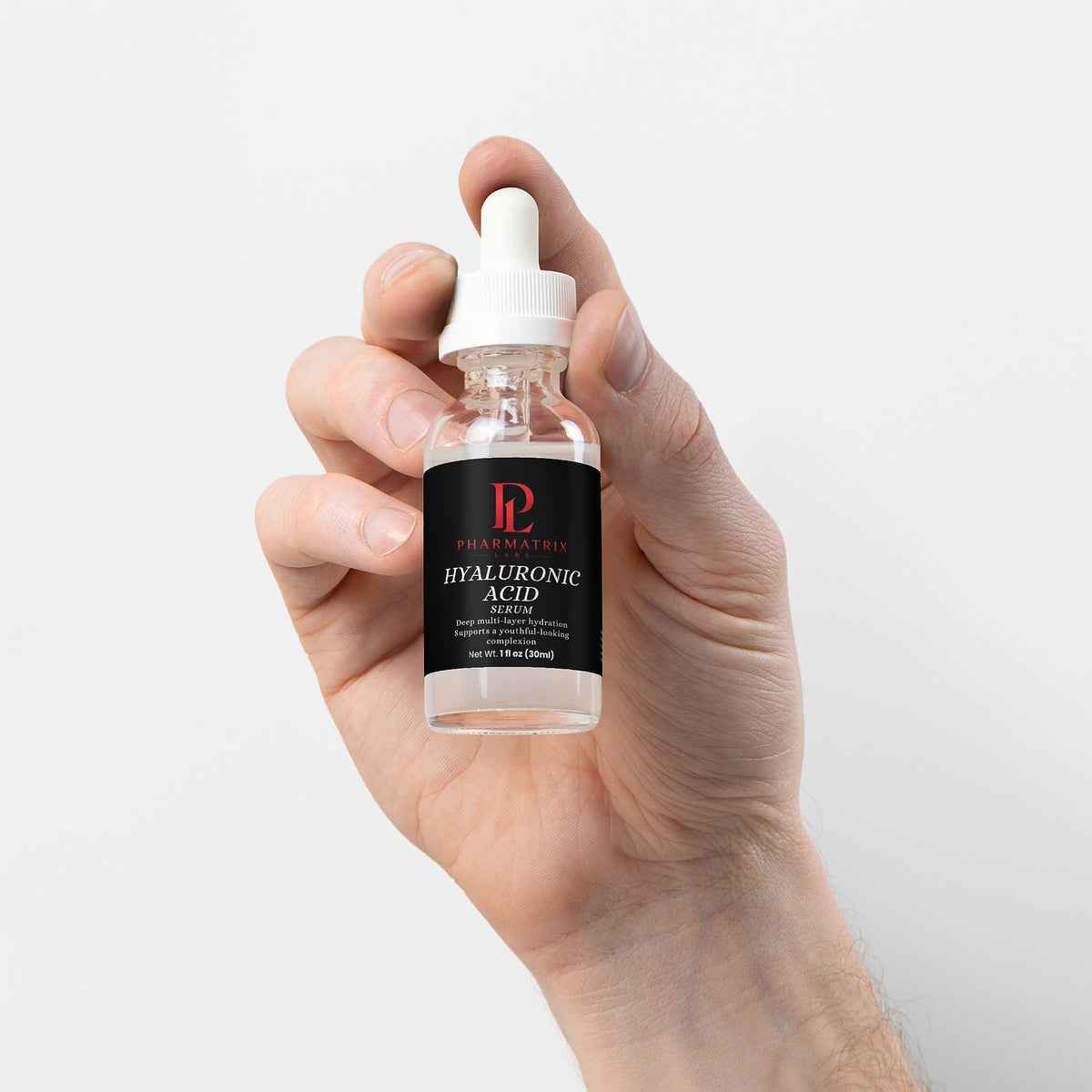 Hand holding a bottle of hyaluronic acid serum with a white background