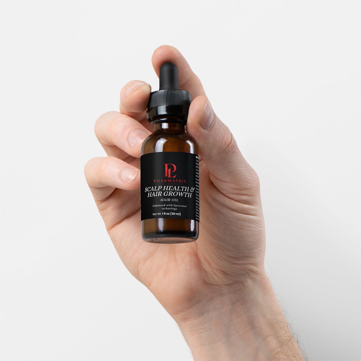 Hand holding a bottle of scalp health and hair growth serum with a plain background