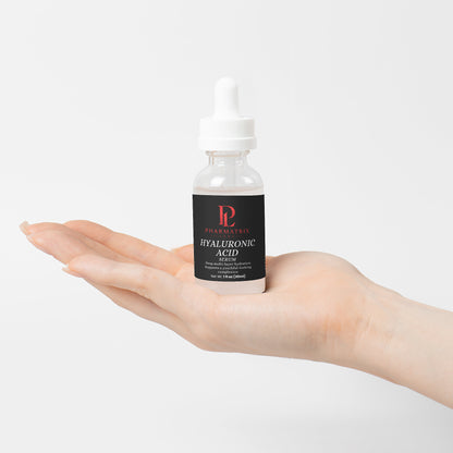 Hand holding a bottle of hyaluronic acid serum against a white background