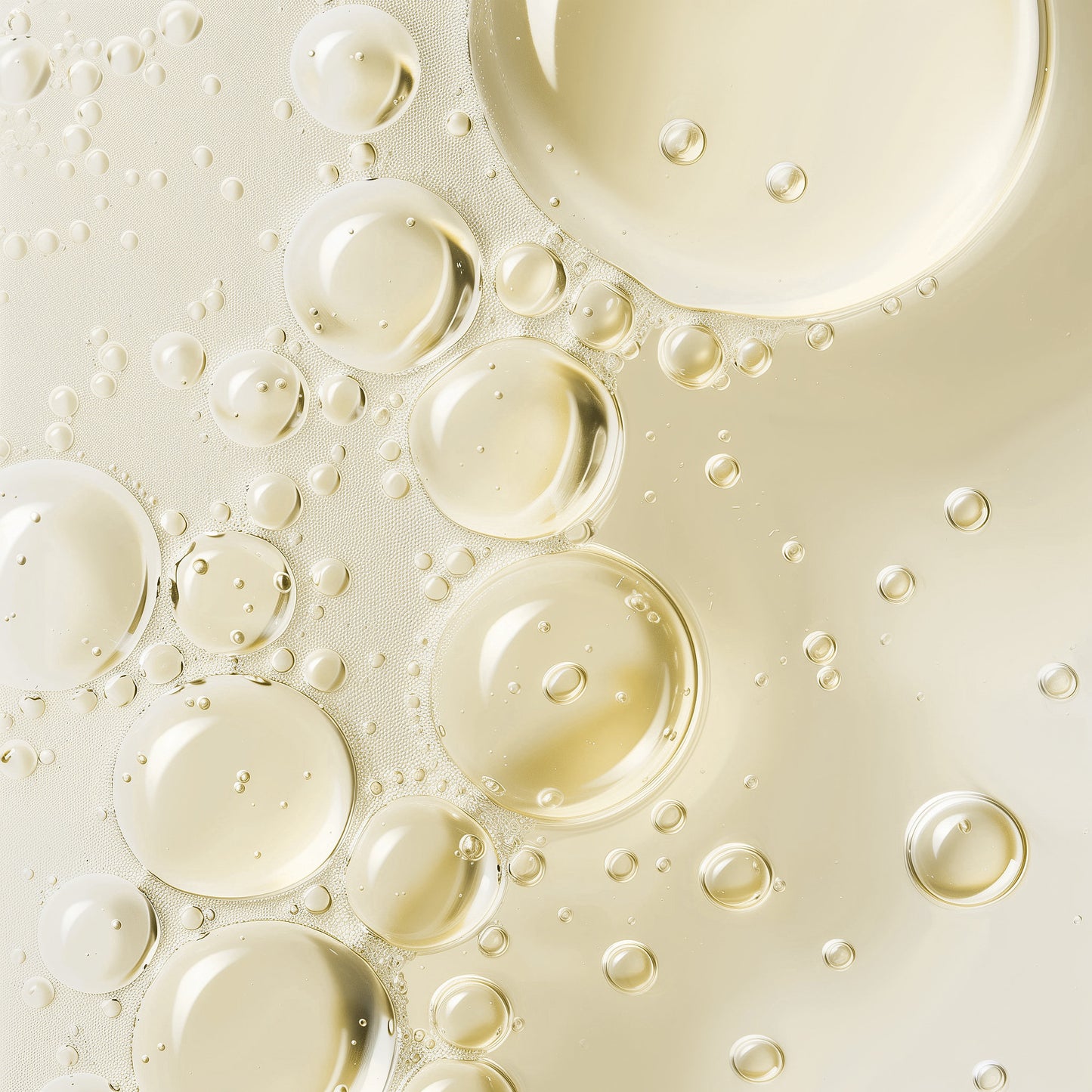 Close-up of oil bubbles (the inside of product) on a light beige background